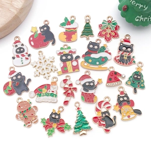 Vue détaillée des breloques de Noël en émail avec motifs de bonhomme de neige et sucre d'orge