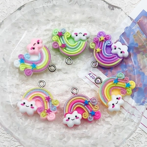 Détail de pendentifs nuage arc-en-ciel en résine colorée pour bijoux DIY sur plateau