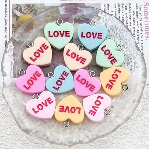 Macro detail of colorful resin heart LOVE pendants with metal rings for DIY jewelry making