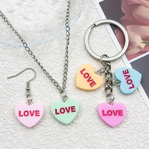 Close-up of heart-shaped Love pendants for DIY jewelry in various pastel colors