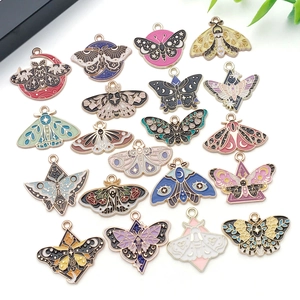 Flat lay detail of assorted colorful enamel butterfly and moth charms with mystic patterns
