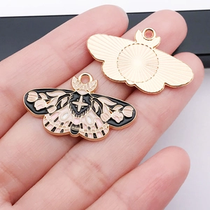 Detailed macro view showing the enamel butterfly charm held to display size and texture