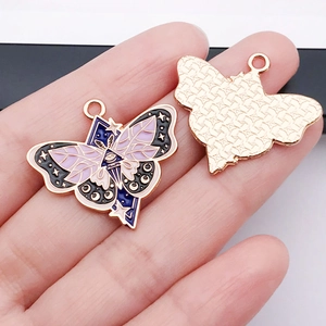 Detail view showing front and back of butterfly enamel charms with mystical moon eye patterns