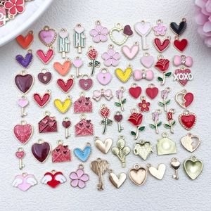 Flat lay of colorful heart and rose alloy charms with gold plating for DIY jewelry making
