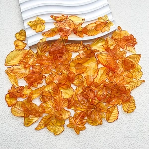 Macro detail of translucent orange acrylic maple leaves for autumn DIY jewelry making