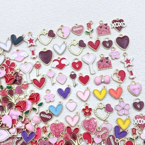 Macro detail of colorful enamel heart and rose charms with XOXO for DIY jewelry making