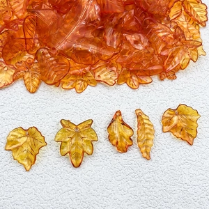 Macro detail of orange acrylic maple leaf pendants for DIY jewelry crafting accessories