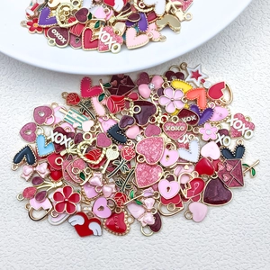 Detail of red and pink heart charms with Love and XOXO enamel for DIY jewelry