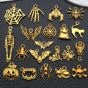 Macro shot of 20 vintage gold Halloween alloy pendants on a black leather background