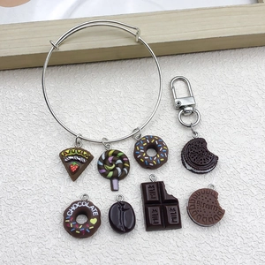 Detail of resin dessert charms including donuts and cakes on a silver bangle and keychain