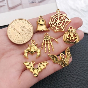 Antique gold Halloween charms set featuring ghosts and pumpkins with size reference coin