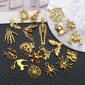 Detailed macro view of antique gold Halloween pendants on a textured black leather background