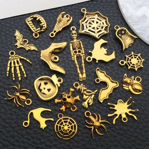 Detail of assorted antique gold Halloween charms on black leather background
