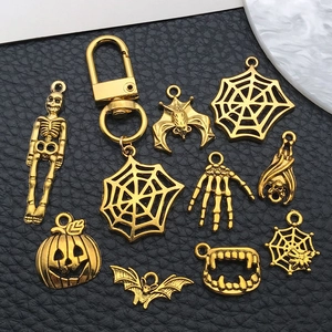 Detailed close-up of various vintage gold Halloween pendants on black leather background