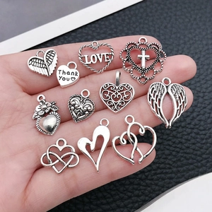 Set di 11 ciondoli a cuore in argento vintage per gioielli fai-da-te nella mano