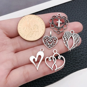 Dettaglio di cinque ciondoli a cuore in argento con moneta per riferimento taglia