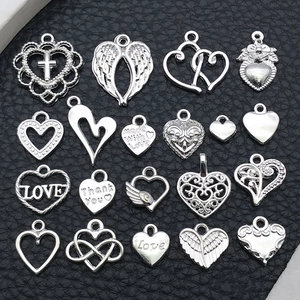 Macro shot of assorted silver heart alloy charms with engraved textures on black leather