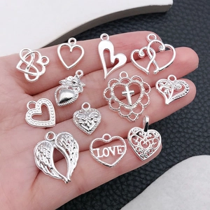 Detailed close-up of various silver heart-shaped alloy charms for DIY jewelry making