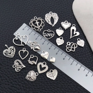 Macro detail of various vintage silver alloy heart pendants and charms with measuring ruler