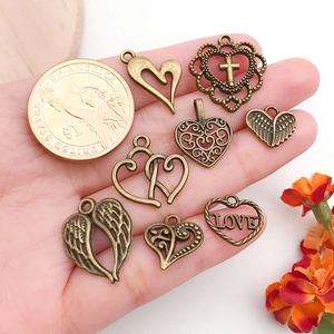 Macro view of vintage bronze alloy heart and wing charms for DIY jewelry making