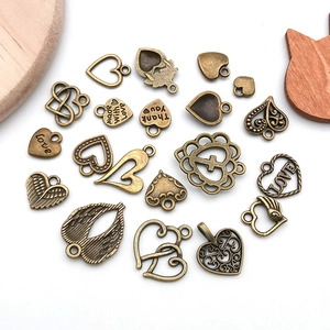 Flat lay of antique bronze heart charms in various designs for DIY jewelry making