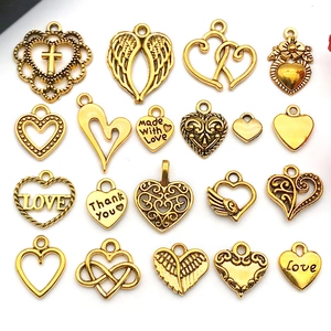 Detailed flat lay of twenty distinct antique gold heart charms with various engravings