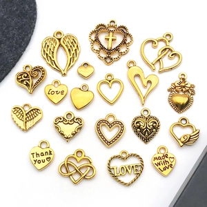 Detail of vintage gold alloy charms including heart shapes with Love and Thank You engravings
