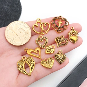 Macro view of vintage gold alloy heart charms with 1 dollar coin for size reference