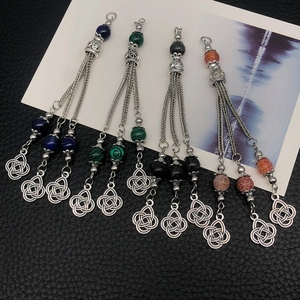 Detailed view of silver ethnic tassels with blue, green, black and orange agate stones