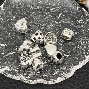 Detailed macro view of vintage silver heart charms with Love and Valentine engraving