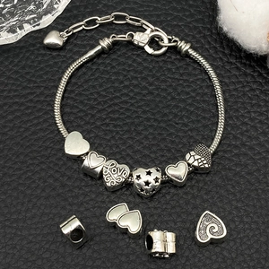 Silver snake chain bracelet with love heart charms and star pendants on black leather