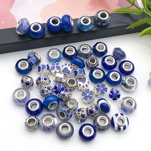 Macro shot of dark blue resin beads and silver-plated charms for DIY jewelry bracelets