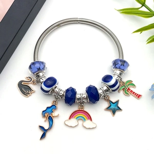 DIY charm bracelet with blue swan, mermaid tail and enamel pendants on silver chain