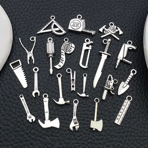 Vue détaillée de breloques d'outils en argent pour bijoux DIY incluant scies et marteaux