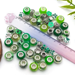 Vue détaillée de perles vertes en résine et breloques trèfles pour création bijoux DIY