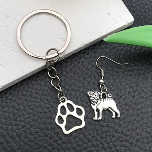 Antique silver pug dog and paw print charm jewelry set on textured stone and leather