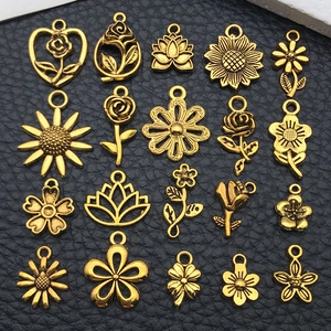 Makroaufnahme von 20 Vintage-Gold-Blumenanhängern für DIY-Schmuckherstellung auf Leder