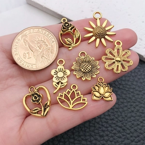 Acht vintage goldene Blumenanhänger Größenvergleich mit einer Dollarmünze für DIY Schmuck