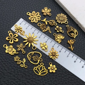 Makroansicht goldener Blumenanhänger mit verschiedenen Blütenformen auf schwarzem Leder