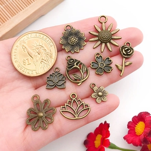 Detailed view of antique bronze alloy floral pendants including rose and sunflower for DIY jewelry