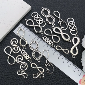 Detailansicht von Infinity-Verbindern in Altsilber mit Love-Schriftzug und Strasssteinen