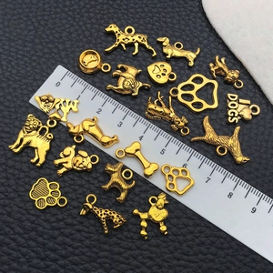 Detail view of gold-tone vintage alloy dog pendants and charms with measuring ruler