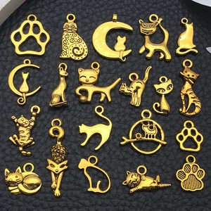 Macro view of various antique gold alloy cat charms and moon pendants for DIY jewelry