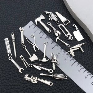 Vue macro de breloques outils vintage en argent sur cuir avec règle de mesure
