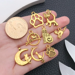Set of 8 gold antique alloy cat charms shown next to a coin for size reference
