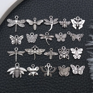 Macro display of twenty vintage silver insect pendants on black textured background