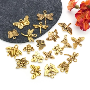 Macro view of vintage gold alloy insect charms including butterflies and honeybees