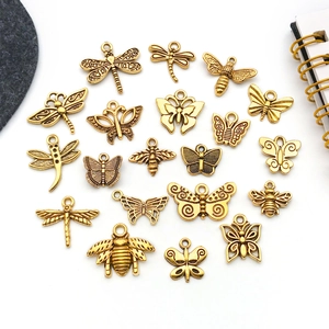 Detailed flat lay of 20 vintage gold alloy insect pendants for jewelry making and DIY