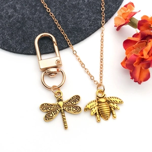 Detail of vintage gold insect charms featuring dragonfly and bee with intricate textures