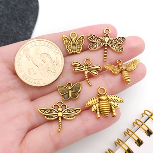 Detailed view of antique gold alloy insect charms including butterflies and dragonflies